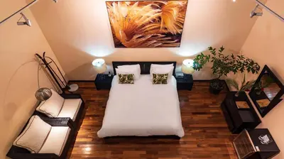 a attic room with a bed and a couch at Gaia Collection Hotels Manuel Antonio in Manuel Antonio