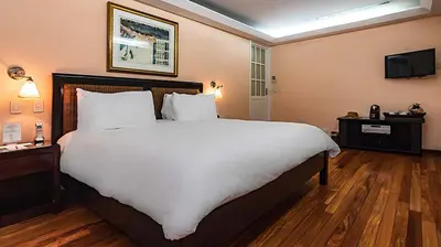 a bedroom with a large bed with white sheets at Gaia Collection Hotels Manuel Antonio in Manuel Antonio