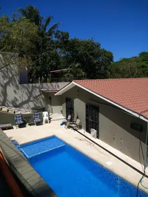 a swimming pool in front of a house at Happy Face House in Bogee