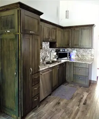 a kitchen with wooden cabinets and a counter top at Happy Face House in Bogee
