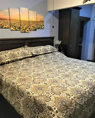 a bed in a bedroom with two paintings on the wall at Happy Face House in Bogee