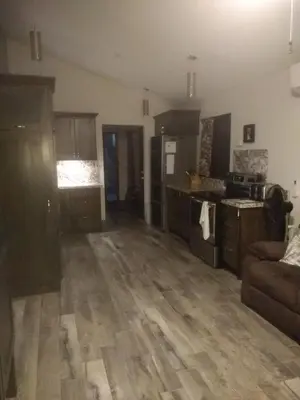a living room with a couch and a kitchen at Happy Face House in Bogee