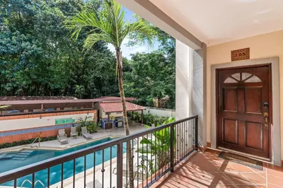 a balcony with a pool and a door and a palm tree at 3-BD Beauty with Pool Near Beach in Santa Cruz