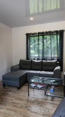 a living room with a couch and a glass table at Holly House La Fortuna in Agua Azul