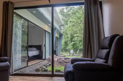 a living room with a large sliding glass door to a patio at Holly House La Fortuna in Agua Azul