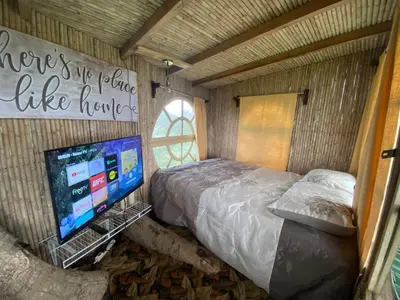 a bedroom with a bed and a tv in it at Casa del Arbol Feel Good in Naranjo