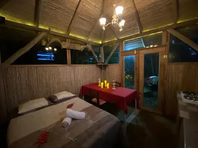 a room with a bed and a small table with a red table at Casa del Arbol Feel Good in Naranjo