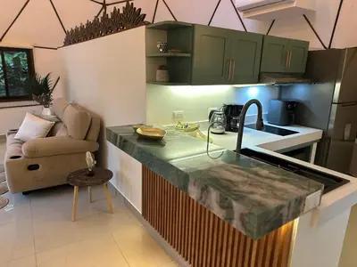 a kitchen with a counter with a sink and a couch at Finca Brisas de la Montaña in Coco