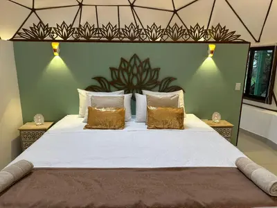 a bedroom with a large bed with gold pillows at Finca Brisas de la Montaña in Coco