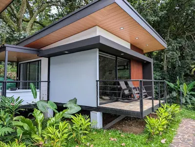 a tiny house with a porch and a deck at Fully furnished lodge with hot tub and pool - Alto Castillo in San José