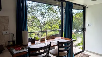 a dining room with a table and a large window at Fully furnished lodge with hot tub and pool - Alto Castillo in San José