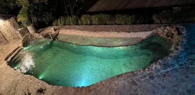 an aerial view of a swimming pool at night at Fully furnished lodge with hot tub and pool - Alto Castillo in San José