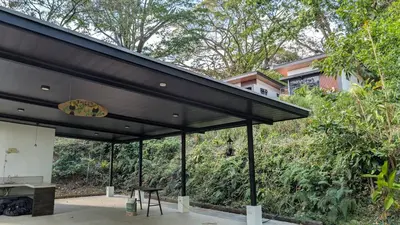 a pavilion with a black roof with a picnic table at Fully furnished lodge with hot tub and pool - Alto Castillo in San José