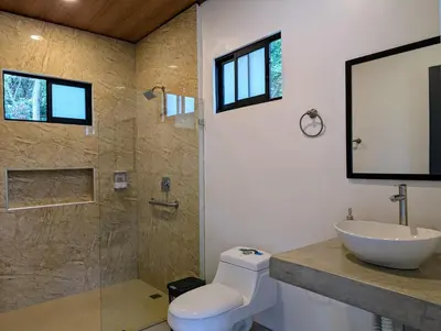 a bathroom with a toilet and a sink and a shower at Fully furnished lodge with hot tub and pool - Alto Castillo in San José