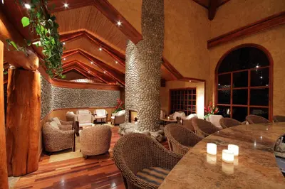 a restaurant with tables and chairs and a fireplace at Peace Lodge in Vara Blanca