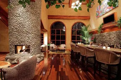 a living room with a fireplace and a table and chairs at Peace Lodge in Vara Blanca
