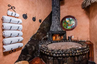 a bathroom with a stone tub with a fireplace at Peace Lodge in Vara Blanca