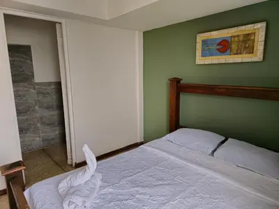 a bedroom with a bed and a painting on the wall at Haven Hotel in San José
