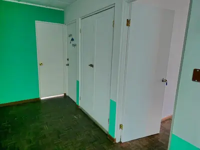 an empty room with green walls and white closets at Haven Hotel in San José