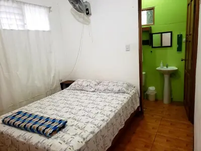 a small bedroom with a bed and a sink at Arenal Hostel La Catarata in Fortuna