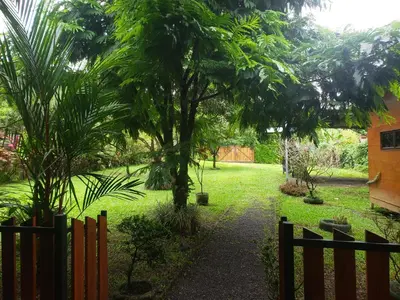 a garden with a fence and a tree at Arenal Hostel La Catarata in Fortuna
