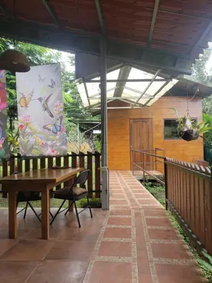 a patio with a wooden bench and a large bag at Arenal Hostel La Catarata in Fortuna