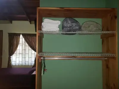 a shelf in a room with towels and a window at Arenal Hostel La Catarata in Fortuna