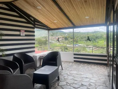 a room with chairs and a table and a large window at Cabinas Vista Al Golfo in Monteverde Costa Rica