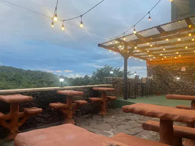 a patio with a table and benches and lights at Cabinas Vista Al Golfo in Monteverde Costa Rica