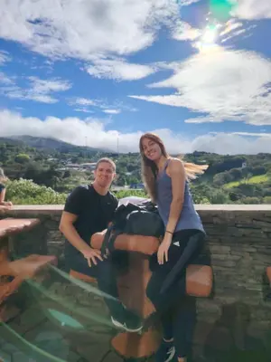a man and a woman sitting on a wall next to a pool at Cabinas Vista Al Golfo in Monteverde Costa Rica