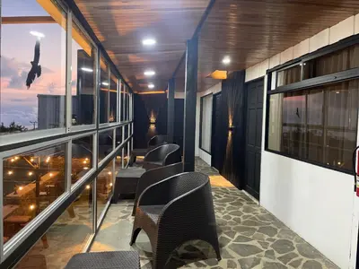 a balcony with chairs and tables on a building at Cabinas Vista Al Golfo in Monteverde Costa Rica
