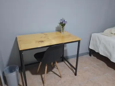 a wooden desk with a vase of flowers on it at Hospedaje Casa Académica in San Pedro