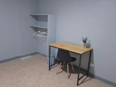 a table and a chair in a room with a closet at Hospedaje Casa Académica in San Pedro