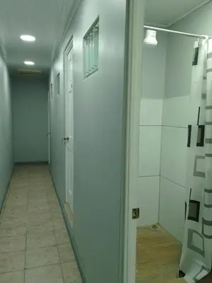 a hallway with white walls and a door and a tile floor at Hospedaje Casa Académica in San Pedro