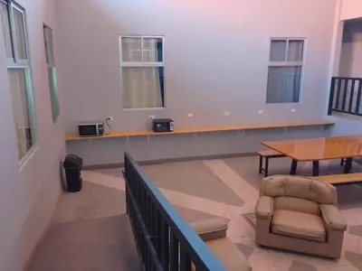 a waiting room with a table and a chair at Hospedaje Casa Académica in San Pedro