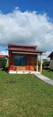 a small house on a grass field with a sidewalk at Cabinas Río celeste in Upala