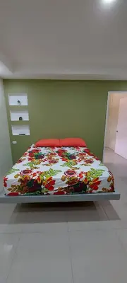a bedroom with a bed with a colorful comforter at Cabinas Río celeste in Upala