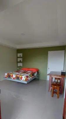 a bedroom with a bed and a wooden table at Cabinas Río celeste in Upala