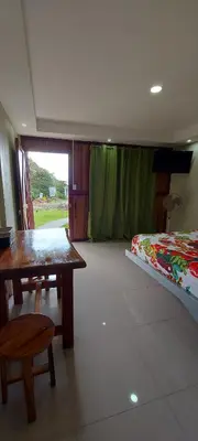 a room with a table and a bed and a table and bench at Cabinas Río celeste in Upala