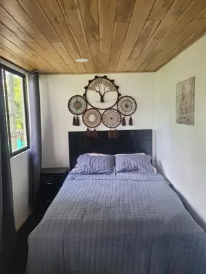 a bedroom with a bed and a clock on the wall at Jungle house in Tapantí