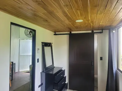 a hallway with a wooden ceiling and a mirror at Jungle house in Tapantí