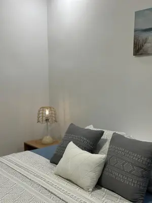 a bedroom with a bed with pillows and a lamp at Condo Apt 3BR,2BA, 4mi from SJO Airport, Pool,Gated, Gym in Desamparados