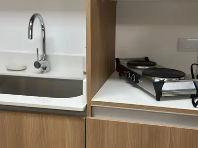 a small kitchen with a stove and a sink at Condo Apt 3BR,2BA, 4mi from SJO Airport, Pool,Gated, Gym in Desamparados