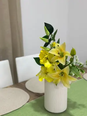 a white vase filled with yellow flowers on a table at Condo Apt 3BR,2BA, 4mi from SJO Airport, Pool,Gated, Gym in Desamparados