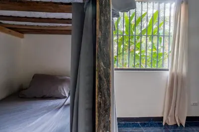 a bedroom with a bunk bed and a window at Tropical Camas Surf House in Pochotal