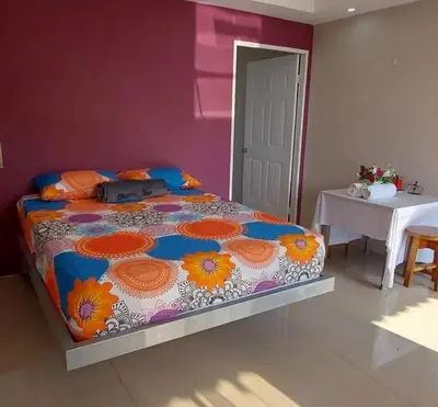 a bedroom with a bed with a colorful comforter at Cabinas Río Celeste in Upala
