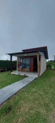 a house with a porch with a table and chairs at Cabinas Río Celeste in Upala