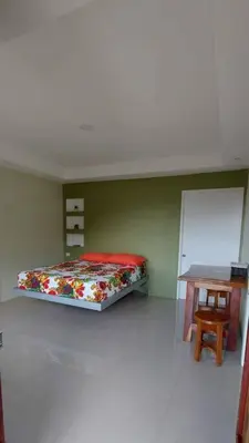 a room with a bed and a table in it at Cabinas Río Celeste in Upala