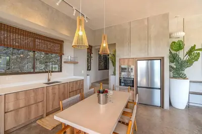 a kitchen with a table and a refrigerator at Blanko Mar Ocean view in Santa Teresa Beach