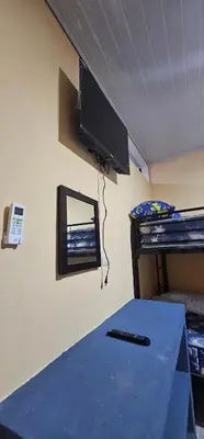 a room with a television and a table with a remote control at Villas Atardecer Tamarindo in Santa Rosa